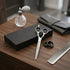 Hair cutting tools including scissors, comb, and hair clips on a wooden surface with a black - viva instruments