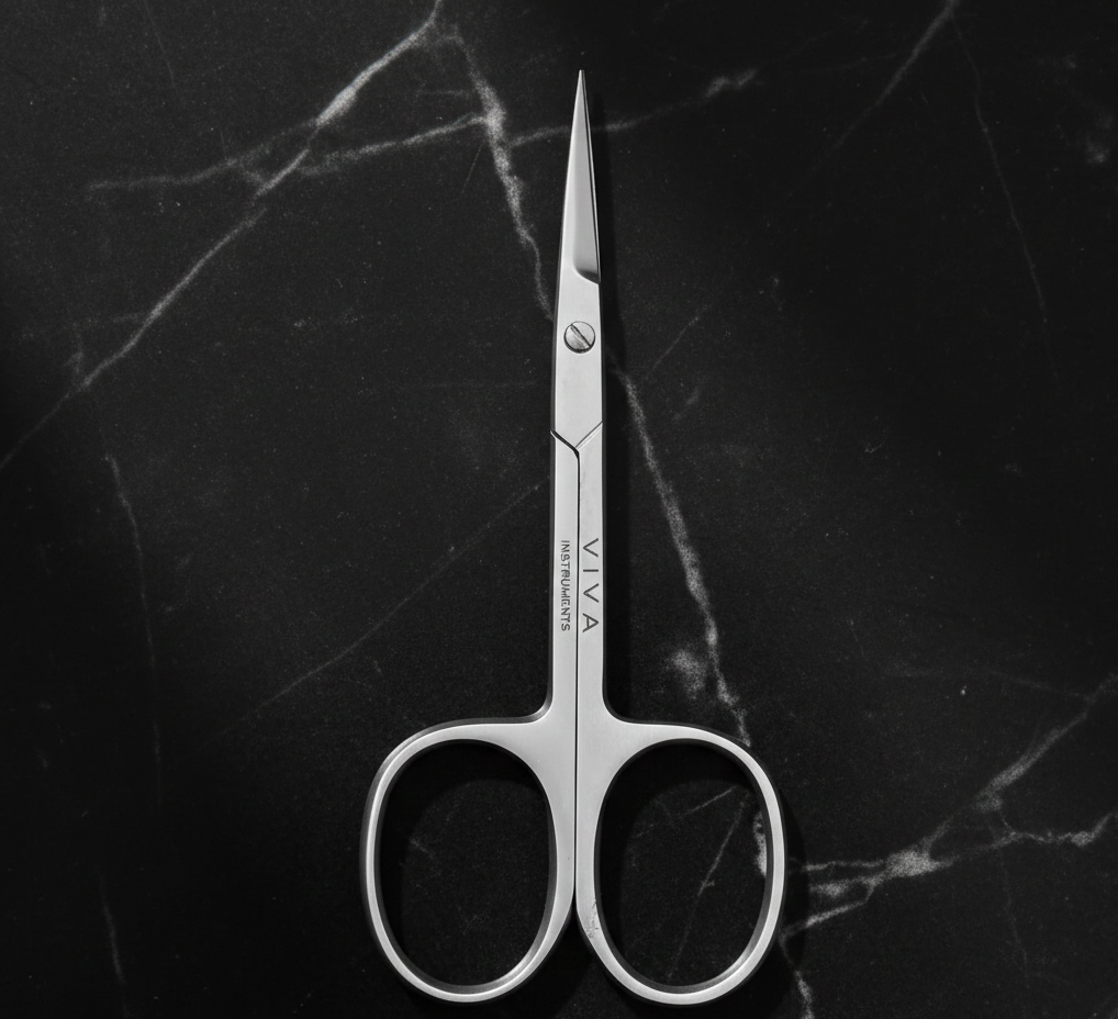 cuticle nail scissors with 'VIVA' branding on a black marble background