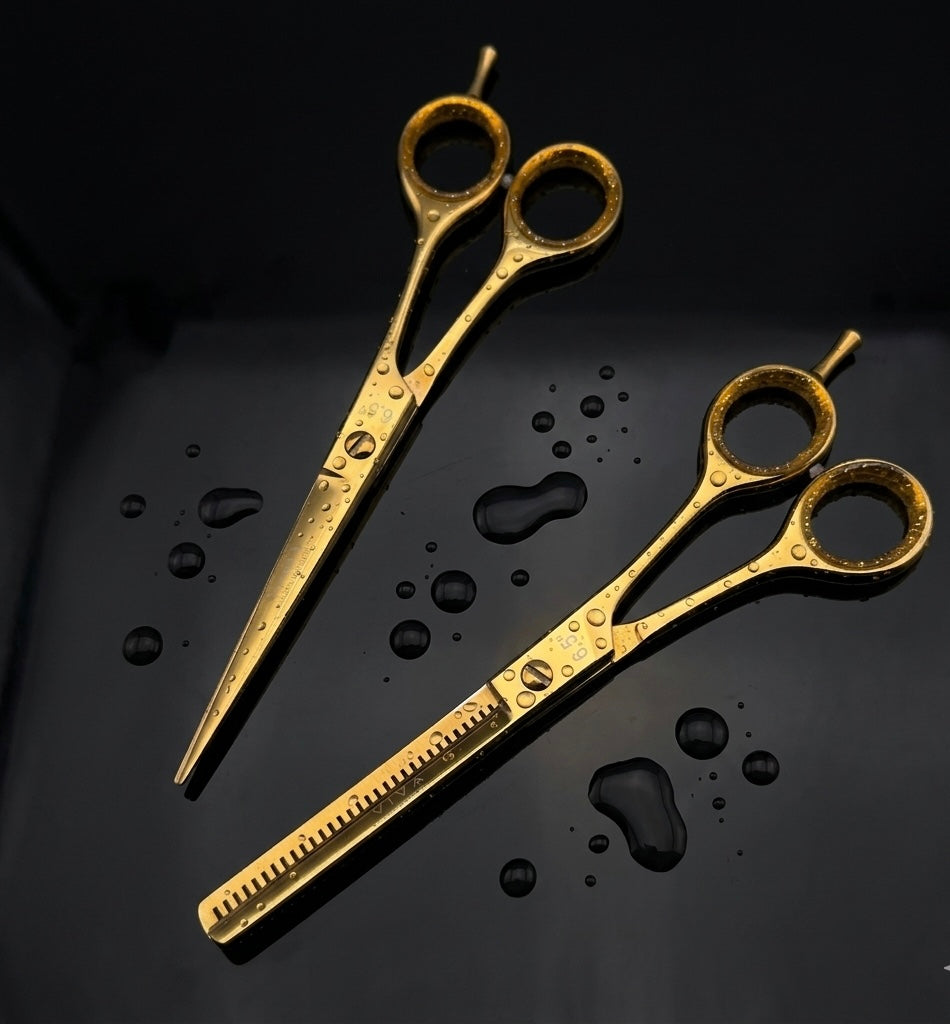 Two gold professional barber scissors on a black background with water droplets - viav instruments 