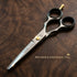 Pair of VIVA barber haircut scissors on a wooden surface with branding and text - viva instruments