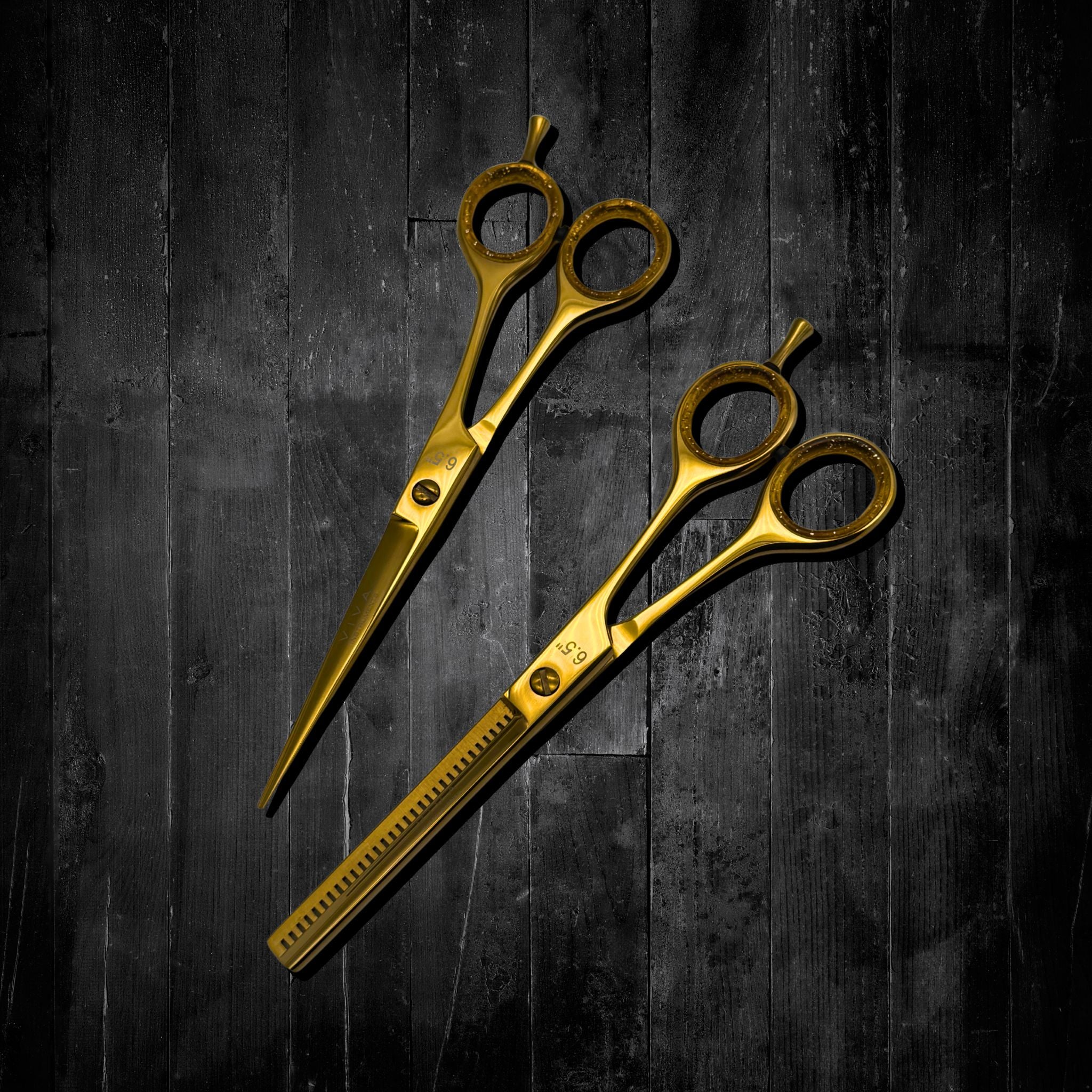 Two gold scissors on a dark wooden surface barber shears scissors