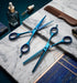 Blue hair cut scissors and a comb on a marble surface with a dark blue background - viva instruments 