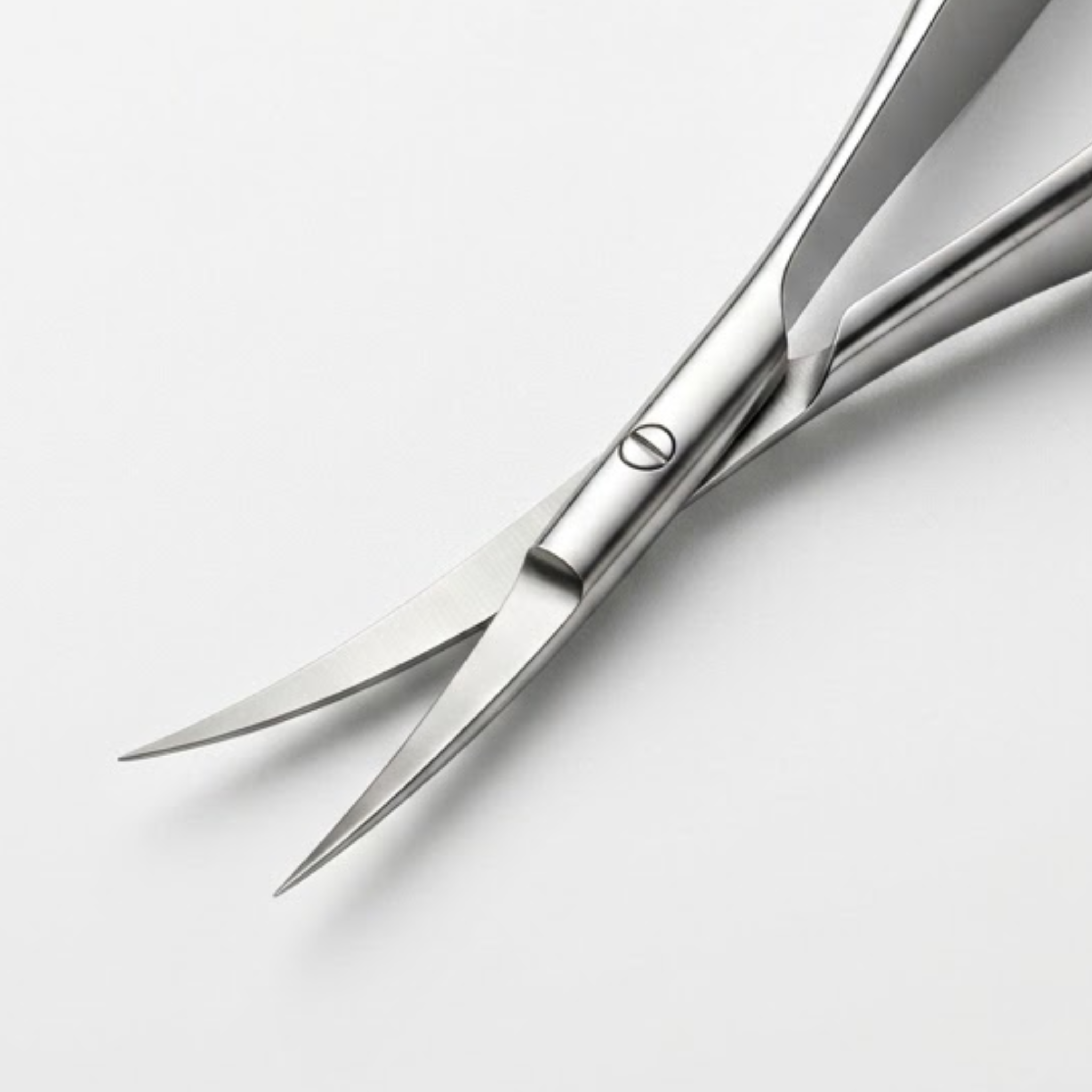 Close-up of polished stainless steel cuticle scissors with sharp curved blades and a single visible screw fastener, photographed on a clean light gray background. Viva Instruments 