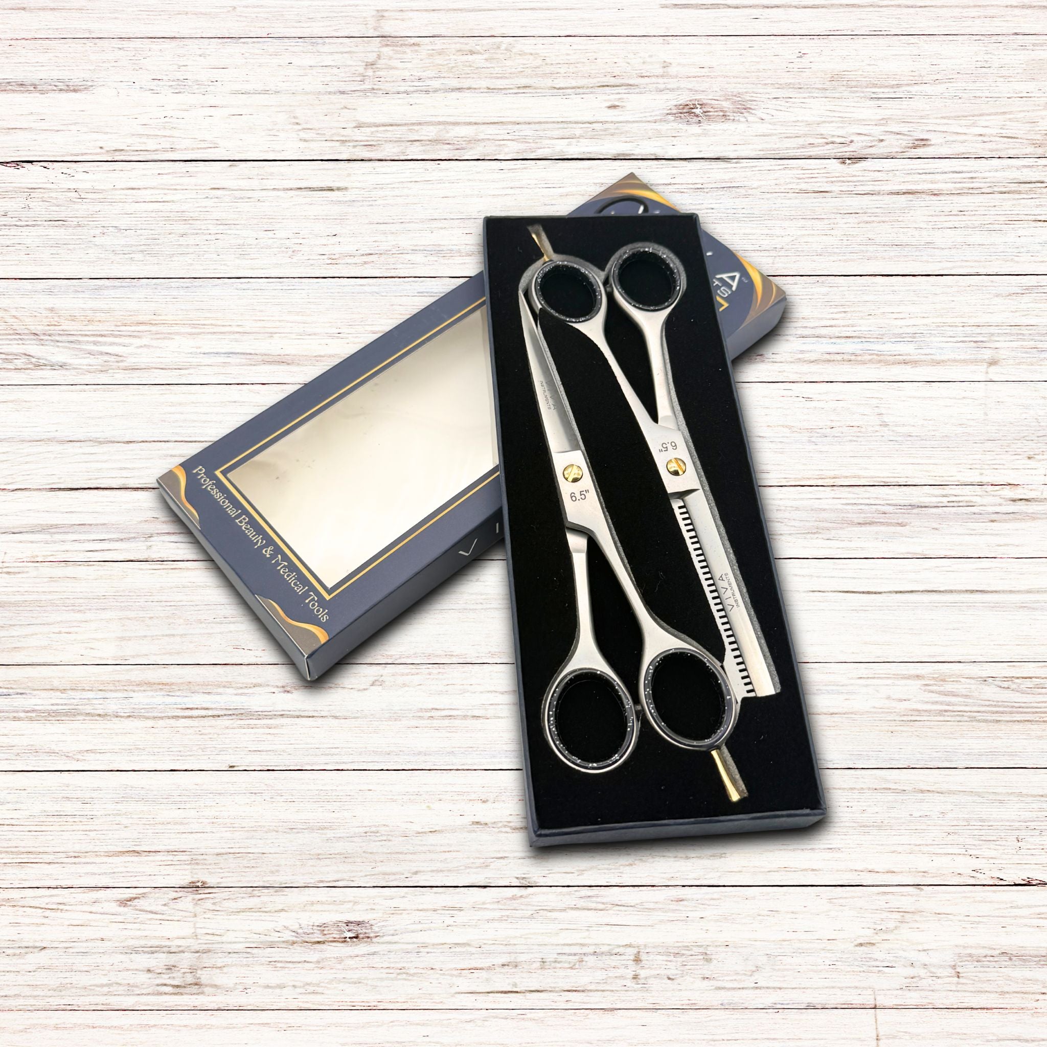 Set of scissors in a black box on a wooden surface
