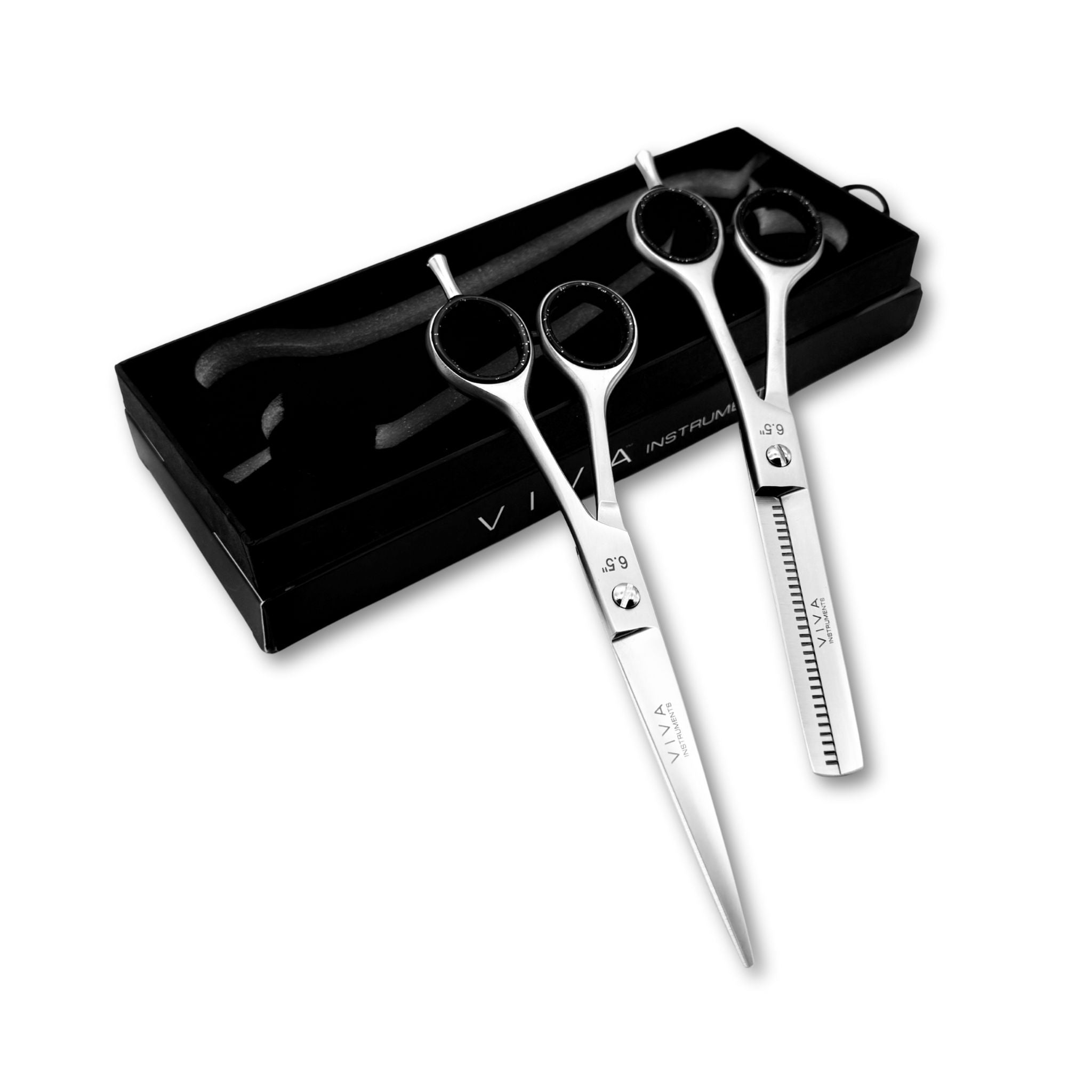 Set of hairdressing scissors with black sheaths on a white background
