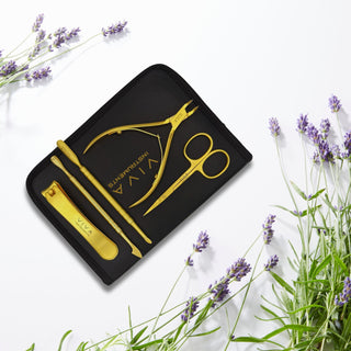 Gold beauty tool set with 'VIVA' branding on a black tray, surrounded by lavender flowers. manicure tools - viva instruments
