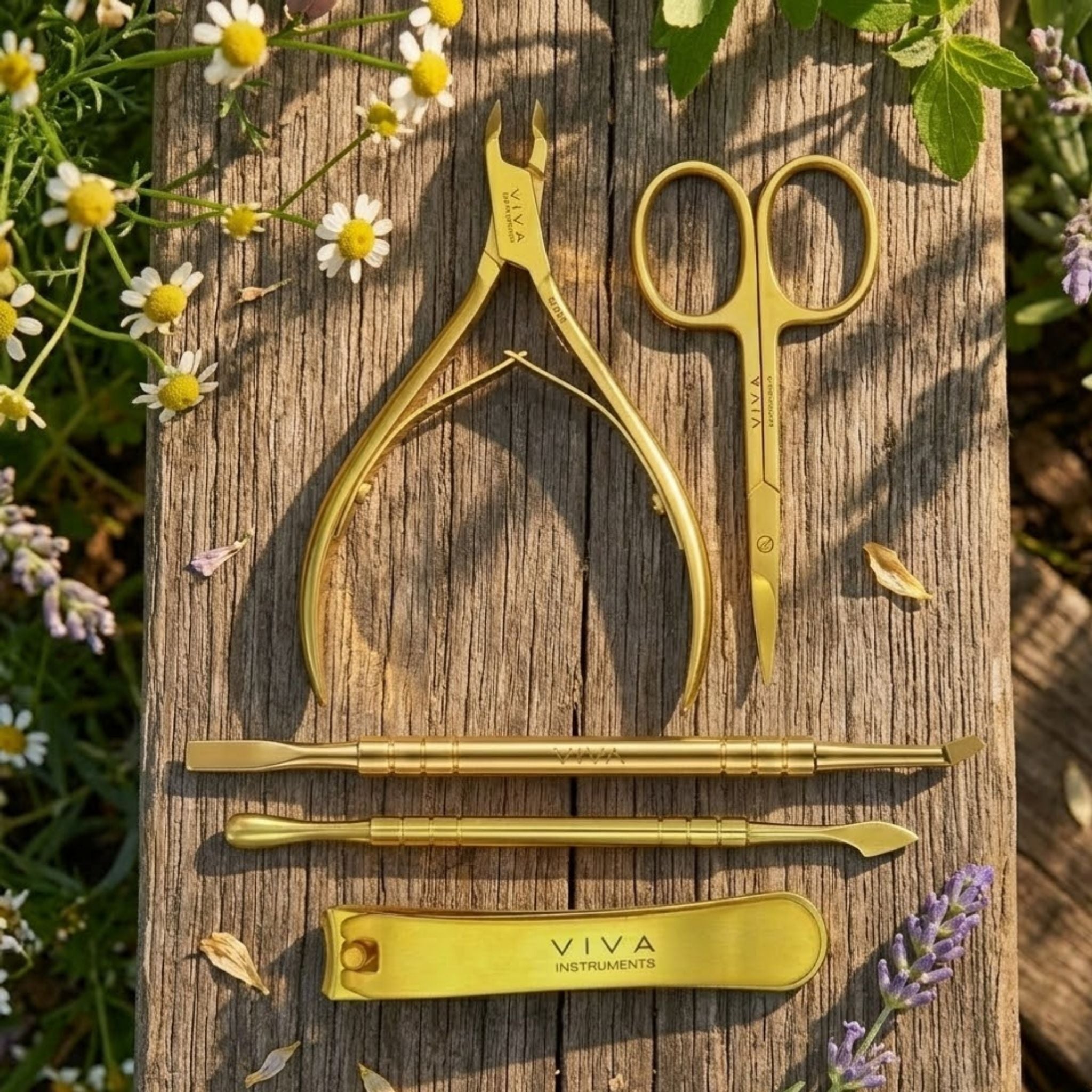 Gold manicure set on a wooden surface with flowers in the background - viva instruments