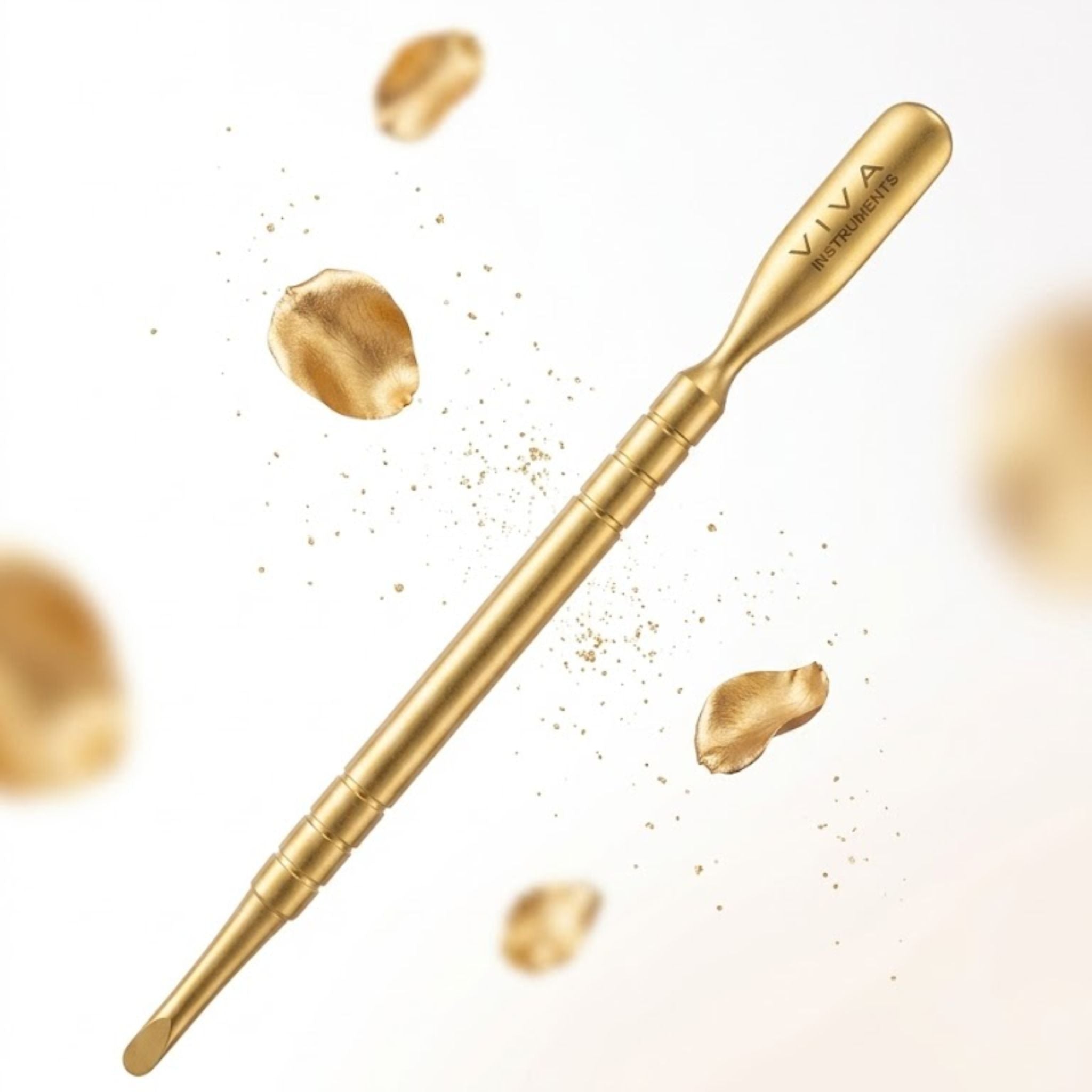 cuticle pushers with 'VIVA' branding on a white background with gold powder.