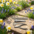 Set of nail care tools on a stone surface with flowers in the background - viav instruments