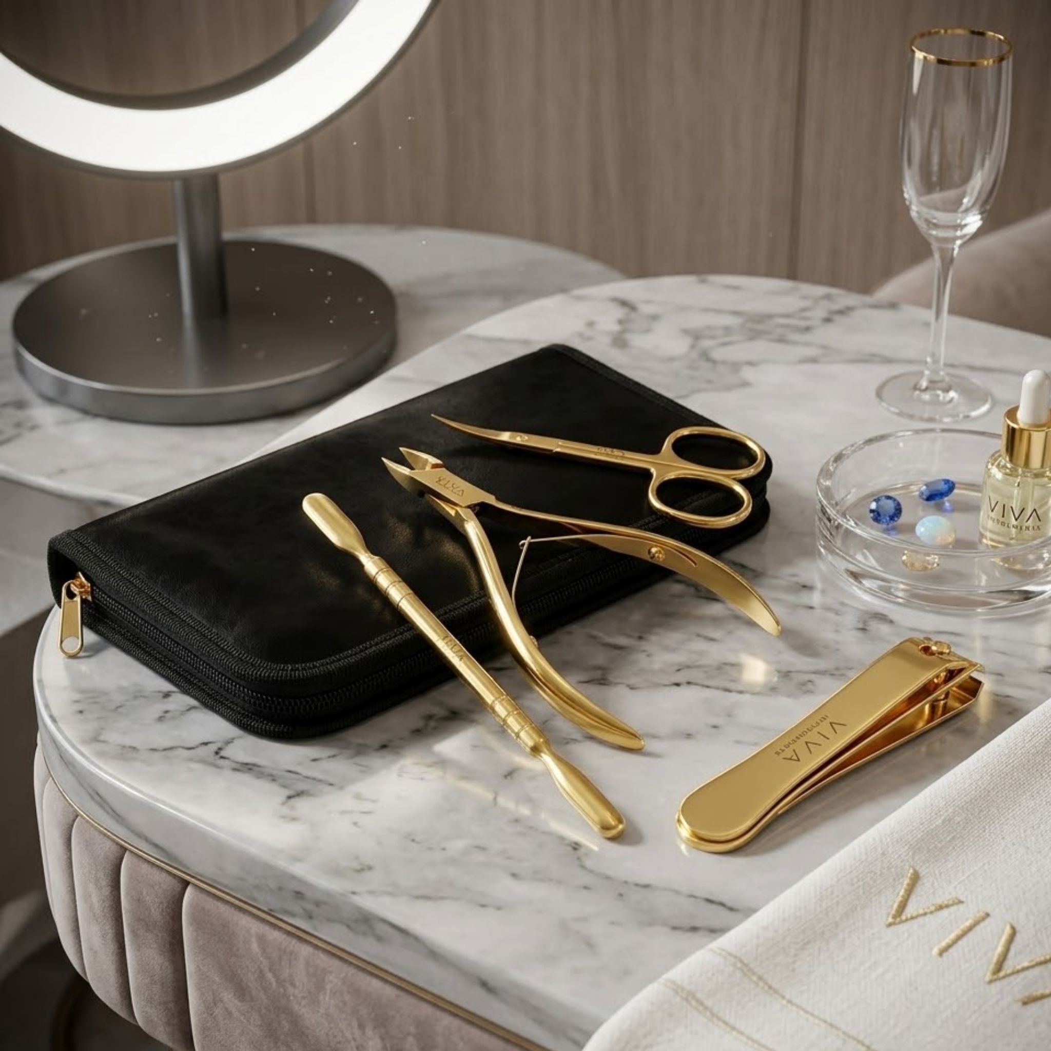 Gold beauty tools including scissors and cuticle nippers, pushers on a marble surface with a black case. viva instruments